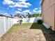 Spacious backyard features a white fence, lush grass, and a beautiful blue sky with fluffy clouds at 4447 Maple Chase Trl, Kissimmee, FL 34758