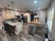 A modern kitchen with stainless steel appliances, a large island with seating, and stylish pendant lights at 4447 Maple Chase Trl, Kissimmee, FL 34758