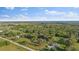 Scenic aerial view of a property surrounded by lush greenery and a glimpse of a distant lake at 4505 Kissimmee Park Rd, St Cloud, FL 34772