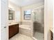 Bright bathroom with a soaking tub, glass shower, and warm vanity at 4720 Doral Pointe Dr, Kissimmee, FL 34758