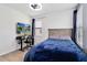 This bedroom features a ceiling fan, a window with blinds, wood floors, and a work desk with dual monitors at 4720 Doral Pointe Dr, Kissimmee, FL 34758