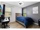 This bedroom has laminate wood flooring, a ceiling fan, a work desk, and a window with views of the neighborhood at 4720 Doral Pointe Dr, Kissimmee, FL 34758