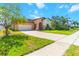 Beautiful home showcasing a well-kept lawn, long driveway, attached garage, and decorative palms for added curb appeal at 4720 Doral Pointe Dr, Kissimmee, FL 34758