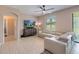 Open floorplan living room with ceiling fan, light-toned tile flooring and comfortable sectional sofa at 4720 Doral Pointe Dr, Kissimmee, FL 34758