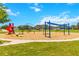 Community playground with swings and a slide set amongst green grass and mulch at 4720 Doral Pointe Dr, Kissimmee, FL 34758