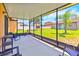 Enclosed screened in porch with chairs, offering outdoor living space overlooking the lawn at 4720 Doral Pointe Dr, Kissimmee, FL 34758
