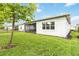 Expansive backyard featuring lush lawn and mature trees with an outdoor screened patio visible at 5025 Sunfalls Ave, St Cloud, FL 34772