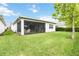 Spacious backyard with manicured lawn and screened patio area, perfect for outdoor gatherings at 5025 Sunfalls Ave, St Cloud, FL 34772