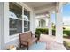 Covered front porch with seating, brick flooring, and landscaped view at 5025 Sunfalls Ave, St Cloud, FL 34772