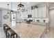 Bright kitchen featuring white cabinets, granite countertops, pendant lighting, and spacious island at 5025 Sunfalls Ave, St Cloud, FL 34772