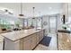 Open-concept kitchen features a large island with granite countertops and modern pendant lighting at 5025 Sunfalls Ave, St Cloud, FL 34772