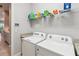 Functional laundry room with modern appliances, overhead shelving, and tiled flooring at 5025 Sunfalls Ave, St Cloud, FL 34772