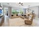 Living room area with plush furniture, ceiling fan, and sliding glass doors to screened lanai at 5025 Sunfalls Ave, St Cloud, FL 34772