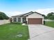 Charming single story home featuring a well-manicured lawn, landscape, and a two-car garage at 5473 Animosh Ct, Polk City, FL 33868