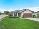 Charming single story home featuring a well-manicured lawn, landscape, and a two-car garage at 5473 Animosh Ct, Polk City, FL 33868