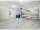 Spacious two car garage, with garage door opener, concrete floor, and cinder block walls at 5473 Animosh Ct, Polk City, FL 33868
