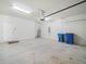 Spacious two car garage, with garage door opener, concrete floor, and cinder block walls at 5473 Animosh Ct, Polk City, FL 33868