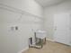 Functional laundry room with a utility sink and shelving at 5473 Animosh Ct, Polk City, FL 33868