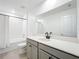 Modern bathroom with a tub, white tiled shower, gray vanity, and expansive mirror at 5712 Bristleleaf Ct, Leesburg, FL 34748