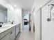 Bright bathroom with double sink vanity, walk-in glass shower, and tile flooring leading to the bedroom at 5712 Bristleleaf Ct, Leesburg, FL 34748
