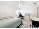 Bright bedroom with a bed, desk, and chair, filled with natural light from the window at 5712 Bristleleaf Ct, Leesburg, FL 34748