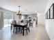 Bright dining area with gray walls featuring an elegant chandelier, an island bar and stainless steel appliances at 5712 Bristleleaf Ct, Leesburg, FL 34748