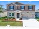 Charming two-story home featuring a well-manicured lawn, a two-car garage and complementary landscaping at 5712 Bristleleaf Ct, Leesburg, FL 34748