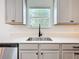 Modern kitchen featuring stainless steel undermount sink, white countertops, and gray cabinets for a clean look at 5712 Bristleleaf Ct, Leesburg, FL 34748