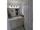 Bright bathroom with white cabinets, granite counters, and a large framed mirror at 5921 Lake Champlain Dr, Orlando, FL 32829