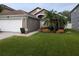 Charming home featuring a manicured front yard with a lovely garden and a two-car garage at 5921 Lake Champlain Dr, Orlando, FL 32829