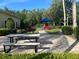 Community playground area with a slide, picnic table, and mature trees, providing a fun space for children at 5921 Lake Champlain Dr, Orlando, FL 32829