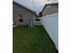 A narrow side yard with healthy grass and white vinyl fencing between homes at 5921 Lake Champlain Dr, Orlando, FL 32829
