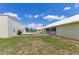 View of the backyard featuring a detached garage, manicured lawn, and a covered patio at 6555 Bay Tree Ct, St Cloud, FL 34771