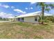Exterior view of the home's rear with screened-in porch and well-maintained lawn at 6555 Bay Tree Ct, St Cloud, FL 34771