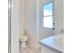 Bright bathroom featuring a white toilet, vanity with a single sink and shower with glass door at 6555 Bay Tree Ct, St Cloud, FL 34771