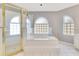 Elegant bathroom featuring a large soaking tub, glass block windows, and a glass-enclosed shower at 6555 Bay Tree Ct, St Cloud, FL 34771