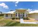 Inviting one-story home featuring a lush lawn, well-maintained landscaping, and a covered entryway at 6555 Bay Tree Ct, St Cloud, FL 34771