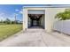 View of the interior of the large, empty detached garage with roll-up door at 6555 Bay Tree Ct, St Cloud, FL 34771