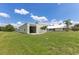 Exterior view of the detached garage, featuring a roll-up door and lush greenery at 6555 Bay Tree Ct, St Cloud, FL 34771