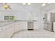 Open kitchen with stainless appliances, tile floors, white cabinets, and view into the living space at 6555 Bay Tree Ct, St Cloud, FL 34771