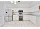 Well-lit kitchen featuring stainless steel appliances, white cabinets, and tile flooring at 6555 Bay Tree Ct, St Cloud, FL 34771