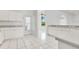 Well-lit kitchen with tile floors, white cabinets, and access to additional living space at 6555 Bay Tree Ct, St Cloud, FL 34771