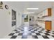 Bright kitchenette featuring white cabinets, checkered floor, stainless fridge and plenty of natural light at 6555 Bay Tree Ct, St Cloud, FL 34771