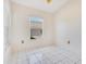 Small room with white tiled flooring, two windows and bare walls at 6555 Bay Tree Ct, St Cloud, FL 34771