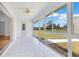 Bright sun room with tiled floors, ceiling fan, and multiple large windows overlooking a lush outdoor view at 6555 Bay Tree Ct, St Cloud, FL 34771