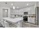 Bright kitchen featuring white cabinets, stainless steel appliances, and a spacious island with seating at 685 Overpool Ave, Davenport, FL 33896