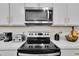 Modern kitchen appliances including a stainless steel microwave and black glass top stove at 685 Overpool Ave, Davenport, FL 33896
