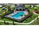 Aerial view of a community pool featuring sun loungers, well-maintained landscaping, and a nearby playground at 685 Overpool Ave, Davenport, FL 33896