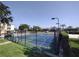 Outdoor basketball court with blue and green surface surrounded by a black fence in a residential community at 8101 Coconut Palm Way # 303, Kissimmee, FL 34747
