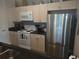 Well-equipped kitchen with stainless steel refrigerator, black countertops and white appliances at 8101 Coconut Palm Way # 303, Kissimmee, FL 34747